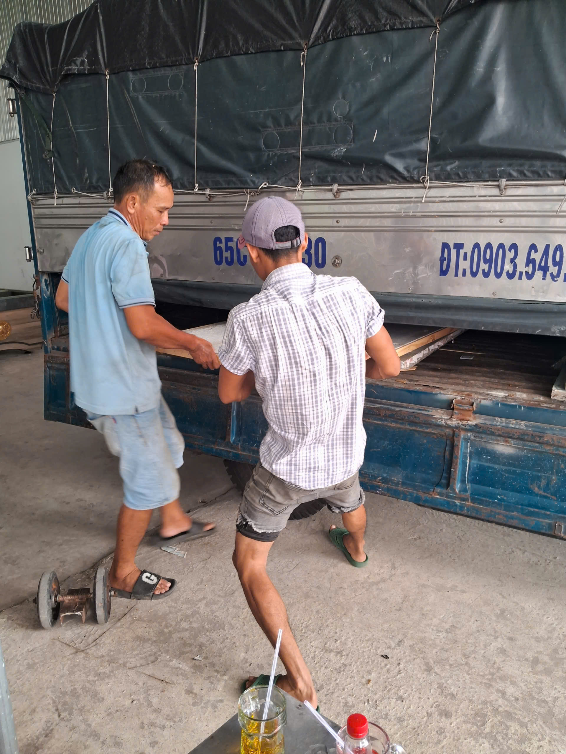 Nhân viên trao đổi khi nhận bàn, minh họa việc đối chiếu thiết bị trong danh sách chuyển.